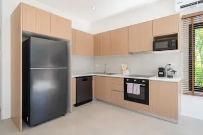a kitchen with a stainless steel refrigerator and cabinets at Villa Chandlers - Goldena Twin in Kamala Beach