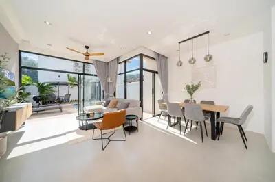 a living room and dining room with a table and chairs at Villa Chandlers - Goldena Twin in Kamala Beach