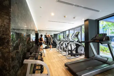a gym with a row of treadmills and elliptical machines at \u82ad\u4e1cThe DECK 6\u516c\u5bd3 \u8fd1\u82ad\u4e1c\u6d77\u6ee9BANGLA\u6c5f\u897f\u51b7 in Patong Beach