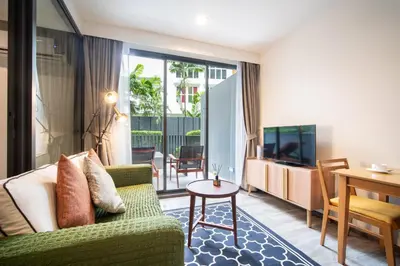 a living room with a green couch and a table at \u82ad\u4e1cThe DECK 6\u516c\u5bd3 \u8fd1\u82ad\u4e1c\u6d77\u6ee9BANGLA\u6c5f\u897f\u51b7 in Patong Beach