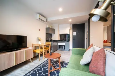 a living room with a couch and a table and a kitchen at \u82ad\u4e1cThe DECK 6\u516c\u5bd3 \u8fd1\u82ad\u4e1c\u6d77\u6ee9BANGLA\u6c5f\u897f\u51b7 in Patong Beach