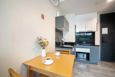 a kitchen with a table with a vase of flowers on it at \u82ad\u4e1cThe DECK 6\u516c\u5bd3 \u8fd1\u82ad\u4e1c\u6d77\u6ee9BANGLA\u6c5f\u897f\u51b7 in Patong Beach