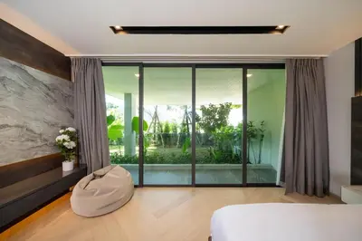 a room with a bed and a large glass window at Elite Villa Patong Phuket in Patong Beach