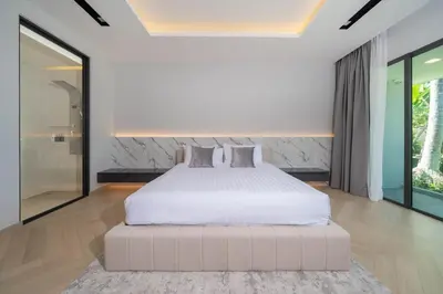 a bedroom with a large bed and a large window at Elite Villa Patong Phuket in Patong Beach