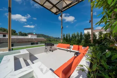 an outdoor patio with orange chairs and a grill at Elite Villa Patong Phuket in Patong Beach