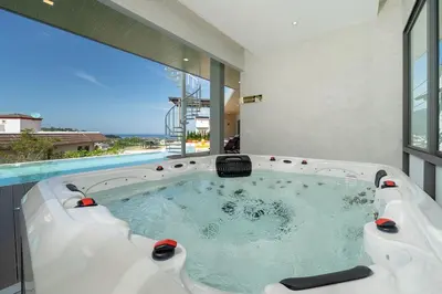 a hot tub in a room with a large window at Elite Villa Patong Phuket in Patong Beach