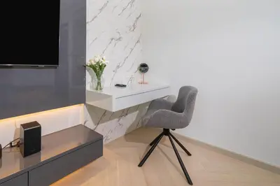 a chair in a room with a tv and a desk at Elite Villa Patong Phuket in Patong Beach