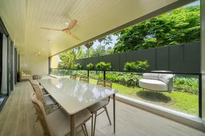 a dining room with a table and chairs on a balcony at Apartment at Laguna Beachside by Lofty in Bang Tao Beach