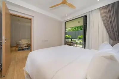 a white bedroom with a large bed and a window at Apartment at Laguna Beachside by Lofty in Bang Tao Beach