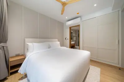 a white bedroom with a large white bed in it at Apartment at Laguna Beachside by Lofty in Bang Tao Beach