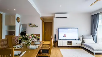 a living room with a table and a television at Beachside Residence 4 floor, Seaside, 250m to the beach in Bang Tao Beach