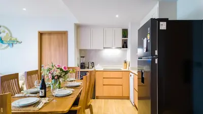 a kitchen with a table and a black refrigerator at Beachside Residence 4 floor, Seaside, 250m to the beach in Bang Tao Beach