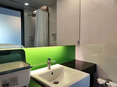 a bathroom with a sink and a green wall at 8 Floor - Mountain view Studio room at TBHR near Kata beach in Kata Beach