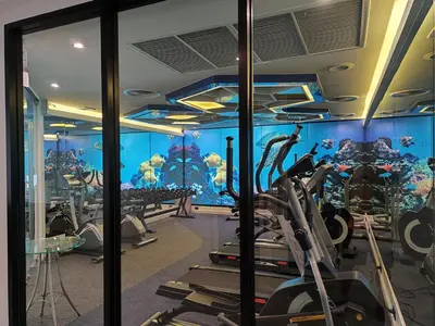 a gym with exercise equipment and an aquarium at 8 Floor - Mountain view Studio room at TBHR near Kata beach in Kata Beach