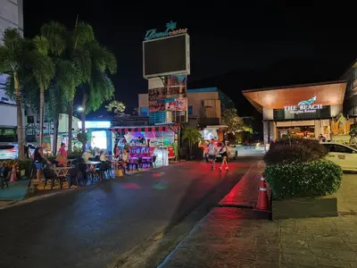 a city street at night with people sitting at tables at 8 Floor - Mountain view Studio room at TBHR near Kata beach in Kata Beach
