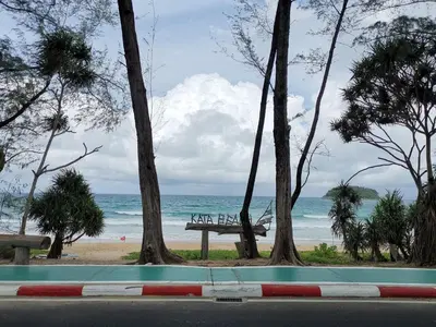 a view of a beach with a bench and trees at 8 Floor - Mountain view Studio room at TBHR near Kata beach in Kata Beach