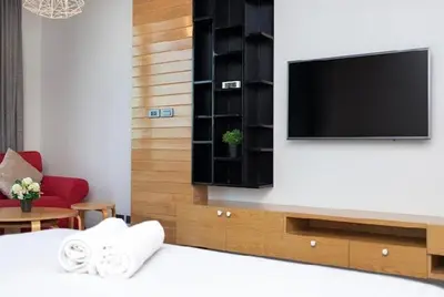 a bedroom with a tv and a bed with towels at Relife 5 mins walk to the beach in Rawai Beach
