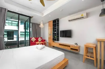 a bedroom with a large bed and a tv on the wall at Relife 5 mins walk to the beach in Rawai Beach