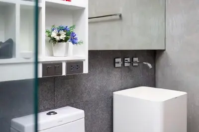 a bathroom with a toilet and a flower pot on a shelf at Relife 5 mins walk to the beach in Rawai Beach