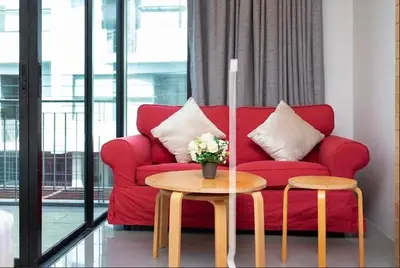 a living room with a red couch and a table at Relife 5 mins walk to the beach in Rawai Beach