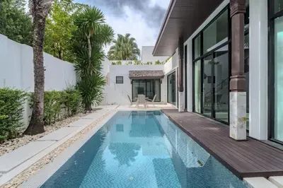 an infinity pool in the backyard of a house at Wings Elegant 2BR Villa Bang Tao Beach in Laguna Phuket