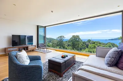 a living room with a couch and a large window at Ocean View 3BR Apartment with Rooftop Terrace, Sapphire Bay 8-19 Residence in Patong Beach