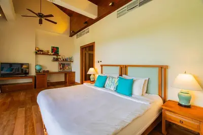a bedroom with a large white bed with blue pillows at 4BR Lakeshore Pool Villa in Laguna Bangtao in Bang Tao Beach