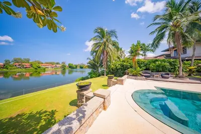 a house with a swimming pool next to a lake at 4BR Lakeshore Pool Villa in Laguna Bangtao in Bang Tao Beach