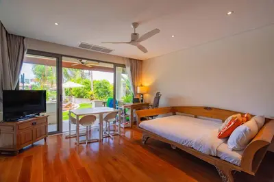 a bedroom with a bed and a television and a table at 4BR Lakeshore Pool Villa in Laguna Bangtao in Bang Tao Beach