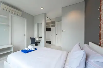a bedroom with a white bed with a blue towel on it at C205 4BR Pool, Mountain Views & Prime Location in Kamala Beach