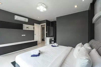 a bedroom with a large white bed with two towels at C205 4BR Pool, Mountain Views & Prime Location in Kamala Beach