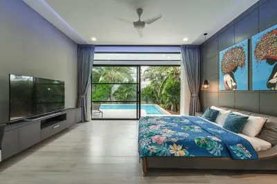 a bedroom with a bed and a tv and a pool at V204 Tropical Score 3BR with Pool, Tub & Snooker in Rawai Beach
