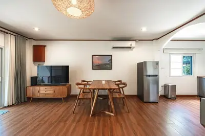 a living room with a table and a television at V205 Island Hideaway Near Promthep Sunset in Nai Harn Beach