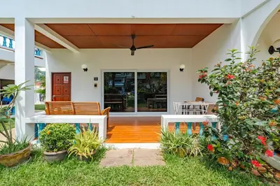 a house with a porch with chairs and flowers at V205 Island Hideaway Near Promthep Sunset in Nai Harn Beach