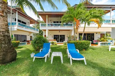 a house with two chairs and a table in the yard at V205 Island Hideaway Near Promthep Sunset in Nai Harn Beach