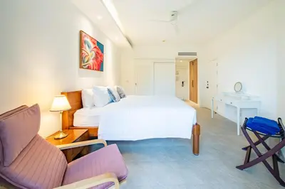 a bedroom with a bed and a desk and a chair at JSD Prime Property-Cherngtalay in Laguna Phuket