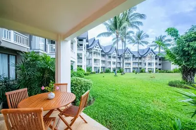 a patio with a table and chairs and a yard at JSD Prime Property-Cherngtalay in Laguna Phuket