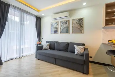 a living room with a couch and a large window at Calipso Garden 108 in Rawai Beach