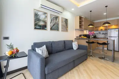 a living room with a couch and a kitchen at Calipso Garden 108 in Rawai Beach