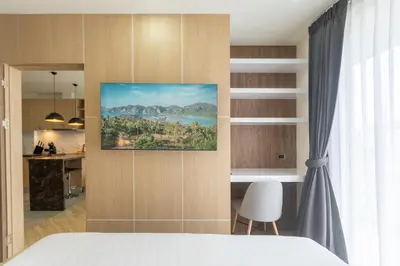 a bedroom with a bed and a painting on the wall at Calipso Garden in Rawai Beach