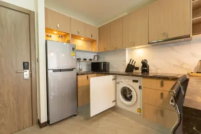 a kitchen with a refrigerator and a washing machine at Calipso Garden in Rawai Beach