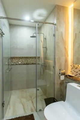 a bathroom with a shower with a glass door at Calipso Garden in Rawai Beach