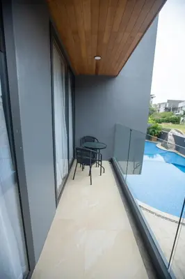 a balcony with a table and a view of a pool at Calipso Garden in Rawai Beach