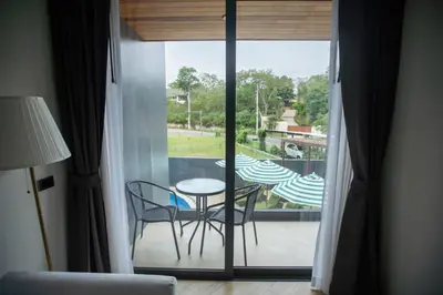 a room with a balcony with a table and chairs at Calipso Garden in Rawai Beach