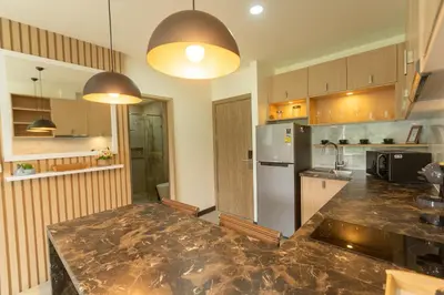a kitchen with a stainless steel refrigerator and cabinets at Calipso Garden in Rawai Beach