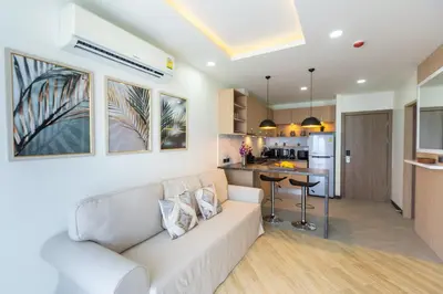 a living room with a couch and a kitchen at Calipso Garden 304 in Rawai Beach