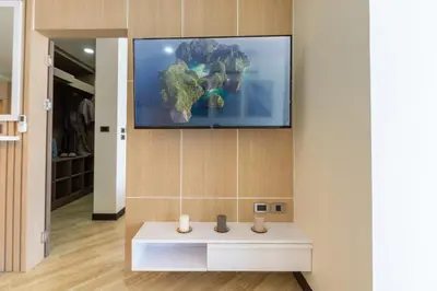 a living room with a tv on a wall at Calipso Garden 304 in Rawai Beach