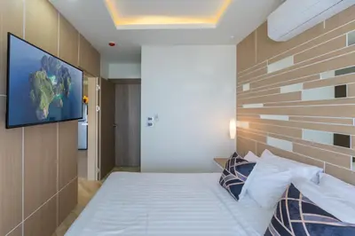 a bedroom with a bed with a tv on the wall at Calipso Garden 304 in Rawai Beach