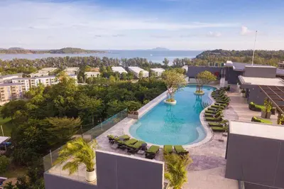 an overhead view of a swimming pool with chairs and trees at Calipso Garden 312 in Rawai Beach