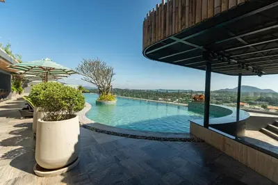 a swimming pool in a building with an umbrella at Calipso Garden 312 in Rawai Beach